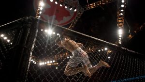 Korea's Chan Sung Jung (left) leaps from the top of the Octagon as he celebrates a technical knock out against Mark Hominick (right) from Thamesford, Ontario during UFC 140 in Toronto on Saturday December 10, 2011. THE CANADIAN PRESS/Chris Young