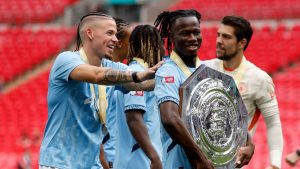 Manchester City's Issa Kabore celebrates with the trophy after his team won the FA Community Shield soccer match between Manchester City and Manchester United at Wembley Stadium in London, Saturday, Aug. 10, 2024. (AP Photo/David Cliff)