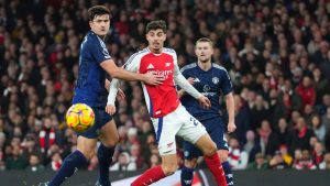 Manchester United's Harry Maguire, left, and Arsenal's Kai Havertz, center, challenge for the ball during the English Premier League soccer match between Arsenal and Manchester United at Emirates stadium in London, Wednesday, Dec. 4, 2024. (Kirsty Wigglesworth/AP)