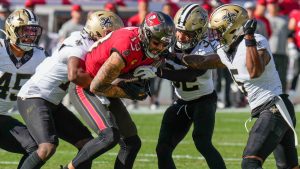 Tampa Bay Buccaneers wide receiver Mike Evans (13) is tackled by New Orleans Saints cornerback Kool-Aid McKinstry (14), safety Tyrann Mathieu (32) and cornerback Will Harris (5) during the first half of an NFL football game Sunday, Jan. 5, 2025, in Tampa, Fla. (Chris O'Meara/AP)