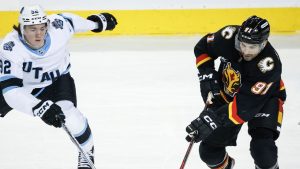 Utah Hockey Club's Logan Cooley, left, and Calgary Flames' Nazem Kadri race for the puck during first period NHL hockey action in Calgary, Alta., Thursday, Jan. 2, 2025. (Jeff McIntosh/CP)