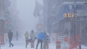 People walk around on Bourbon Street as snow falls in the French Quarter in New Orleans, Tuesday, Jan. 21, 2025. (Gerald Herbert/AP)