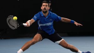 Novak Djokovic of Serbia plays a forehand return to Carlos Alcaraz of Spain during their quarterfinal match at the Australian Open tennis championship in Melbourne, Australia, Wednesday, Jan. 22, 2025. (AP/Ng Han Guan)