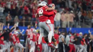 Ohio State quarterback Will Howard, middle left, is congratulated by offensive lineman Josh Fryar after throwing a touchdown pass during the first half of the Cotton Bowl College Football Playoff semifinal game against Texas, Friday, Jan. 10, 2025, in Arlington, Texas. (Julio Cortez/AP)