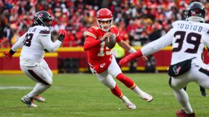 Kansas City Chiefs quarterback Patrick Mahomes scrambles away from pressure applied by Houston Texans defensive tackle Tim Settle Jr. and Texans linebacker Henry To'oTo'o during the first half of an NFL divisional playoff game, Saturday, Jan. 18, 2025 in Kansas City, Mo. (AP/Reed Hoffmann)