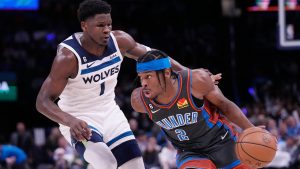 Oklahoma City Thunder guard Shai Gilgeous-Alexander (2) drives around Minnesota Timberwolves guard Anthony Edwards (1) in the second half of an NBA basketball game Friday, Dec. 16, 2022, in Oklahoma City. (AP Photo/Sue Ogrocki)