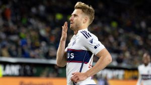 Vancouver Whitecaps midfielder Stuart Armstrong, right, celebrates the goal against the Portland Timbers during the second half of an MLS soccer match Wednesday, Oct. 23, 2024, in Portland, Ore. (AP Photo/Howard Lao)