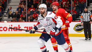 Tom Wilson of the Washington Capitals battles for position with Calgary Flames defenceman Rasmus Andersson. (Gerry Thomas/NHLI via Getty Images)