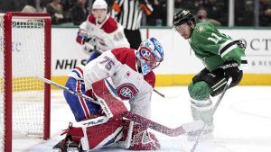 Montreal Canadiens goaltender Jakub Dobes (75) covers up a shot under pressure from Dallas Stars center Logan Stankoven (11) in the first period of an NHL hockey game in Dallas, Thursday, Jan. 16, 2025. (Tony Gutierrez/AP)