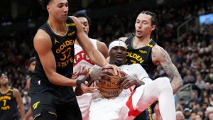 Toronto Raptors forward Chris Boucher (25) battles for the ball with Golden State Warriors forward Trayce Jackson-Davis (32) and teammate Lindy Waters III (43) during second half NBA basketball action in Toronto, Monday, Jan. 13, 2025. (Nathan Denette/CP)