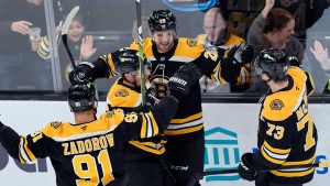 Boston Bruins' Elias Lindholm (28) celebrates his goal with Nikita Zadorov (91), Charlie McAvoy (73) and Brad Marchand (63) during the second period of an NHL hockey game. (Michael Dwyer/AP)