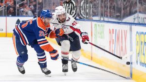 Washington Capitals' Tom Wilson (43) and Edmonton Oilers' Darnell Nurse (25) battle for the puck during third period NHL action in Edmonton on Tuesday, January 21, 2025. (Jason Franson/CP)