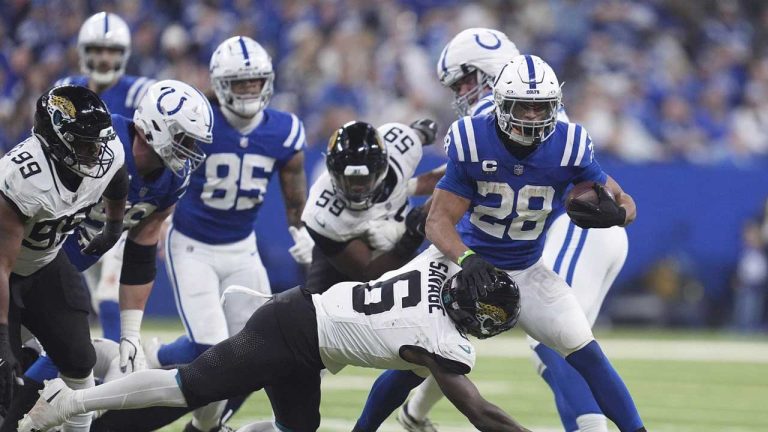 Indianapolis Colts running back Jonathan Taylor (28) runs with the ball as Jacksonville Jaguars safety Darnell Savage (6) and defensive tackle Jeremiah Ledbetter (99) move in during the first half of an NFL football game. (Michael Conroy/AP)