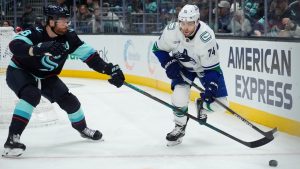 Seattle Kraken defenceman Adam Larsson, left, reaches for the puck against Vancouver Canucks left wing Jake DeBrusk (74) during the first period of an NHL hockey game Thursday, Jan. 2, 2025, in Seattle. (Lindsey Wasson/AP)