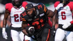 William Stanback loses his helmet after being hit by Ottawa Redblacks' Adarius Pickett during the first half of a CFL football game. (Darryl Dyck/CP)