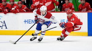 Montreal Canadiens defenceman Kaiden Guhle, left, keeps the puck away from Detroit Red Wings left wing Lucas Raymond during the third period of an NHL hockey game, Thursday, Jan. 23, 2025, in Detroit. (Jose Juarez/AP)