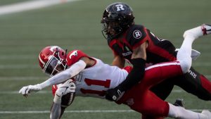 Ottawa Redblacks' Justin Howell tackles Calgary Stampeders wide receiver Malik Henry during first half CFL action in Ottawa on June 15, 2023. (Adrian Wyld/CP)