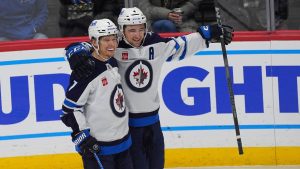 Winnipeg Jets centre Vladislav Namestnikov, left, congratulates defenceman Neal Pionk after he scored the winning goal in overtime of an NHL hockey game against the Colorado Avalanche Wednesday, Jan. 22, 2025, in Denver. (David Zalubowski/AP)