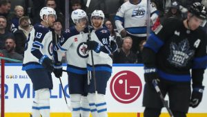 Winnipeg Jets left wing Kyle Connor (81) celebrates with teammates Gabriel Vilardi (13) and Mark Scheifele (55) after scoring as Toronto Maple Leafs centre John Tavares (91) skates away during second period NHL action in Toronto on Monday, Dec. 23, 2024. (Nathan Denette/CP)