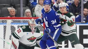 Toronto Maple Leafs' Auston Matthews (34) and Minnesota Wild's Joel Eriksson Ek (14) battle in front of Wild goaltender Filip Gustavsson (32) during first period NHL hockey action in Toronto on Wednesday, January 29, 2025. (Frank Gunn/CP)