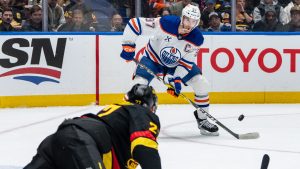 Edmonton Oilers' Connor McDavid (97) prepares to shoot as Vancouver Canucks' Derek Forbort (27) defends during the second period of an NHL hockey game in Vancouver, on Saturday, January 18, 2025. (Ethan Cairns/CP)