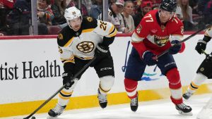 Boston Bruins center Elias Lindholm (28) skates with the puck as Florida Panthers defenseman Niko Mikkola (77) defends during the first period of an NHL hockey game, Saturday, Jan. 11, 2025, in Sunrise, Fla. (Lynne Sladky/AP)