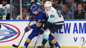 Buffalo Sabres defenceman Rasmus Dahlin (26) and Seattle Kraken right wing Kaapo Kakko (84) battle for the puck during the first period of an NHL hockey game Saturday, Jan. 11, 2025, in Buffalo, N.Y. (Jeffrey T. Barnes/AP)