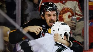 Los Angeles Kings' Kyle Burroughs, right, fights with Calgary Flames' Ryan Lomberg during third period NHL hockey action in Calgary on Saturday, Jan. 11, 2025. (Jeff McIntosh/CP)