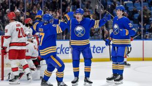 Buffalo Sabres centre Ryan McLeod, centre, celebrates with left wing Jason Zucker, left, and defenseman Owen Power (25) after scoring during the second period of an NHL hockey game against the Carolina Hurricanes in Buffalo, N.Y., Wednesday, Jan. 15, 2025. (Adrian Kraus/AP Photo)