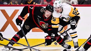 Ottawa Senators left wing Brady Tkachuk (7) and Pittsburgh Penguins centre Noel Acciari (55) watch the puck during second period NHL hockey action in Ottawa, on Saturday, Dec. 23, 2023. (Justin Tang/THE CANADIAN PRESS)