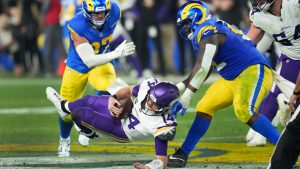 Los Angeles Rams defensive tackle Neville Gallimore (92) sacks Minnesota Vikings quarterback Sam Darnold (14) during the second half of an NFL wild card playoff football game, Monday, Jan. 13, 2025, in Glendale, Ariz. (Ross D. Franklin/AP)