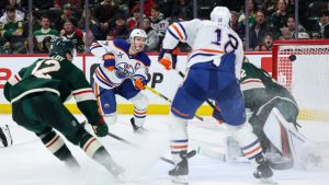 Edmonton Oilers center Connor McDavid, second from the left, scores a goal past Minnesota Wild goaltender Filip Gustavsson during the third period of an NHL hockey game Wednesday, Jan. 15, 2025, in St. Paul, Minn. (Matt Krohn/AP)