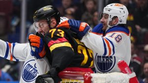 Vancouver Canucks' Vincent Desharnais (73) gets into a scuffle with Edmonton Oilers' Zach Hyman (18) and Connor McDavid, back left, during the first period of an NHL hockey game in Vancouver, on Saturday, November 9, 2024. (Darryl Dyck/CP)