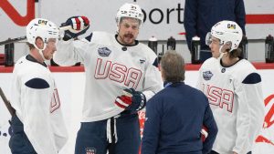 United States' Auston Matthews, centre, Jack Eichel, left and Jack Hughes, right speak with coaching staff during during 4 Nations Face-Off hockey practice in Brossard, Que., on Monday, Feb. 10, 2025. (CP/Christinne Muschi)