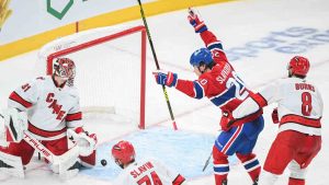 Montreal Canadiens' Juraj Slafkovsky (20) reacts to a goal by teammate Lane Hutson (not shown) on Carolina Hurricanes goaltender Frederik Andersen (31) as Hurricanes' Jaccob Slavin (74) and Brent Burns (8) defend during third period NHL hockey action in Montreal, Tuesday, February 25, 2025. (Graham Hughes/CP)