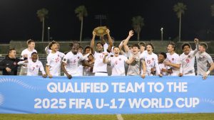 Canada captain Richard Chukwu holds the trophy high as he and teammates celebrate after defeating host Bermuda 7-1, in Hamilton, Bermuda, on a Sunday, Feb. 16, 2025, handout photo. THE CANADIAN PRESS/HO-Canada Soccer, John Lobban