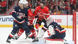 Canada's Mitch Marner (16) and Mark Stone (61) move in on United States goaltender Connor Hellebuyck (37) as United States' Noah Hanifin (15) defends during third period 4 Nations Face-Off hockey action in Montreal, Saturday, February 15, 2025. (Graham Hughes/CP)