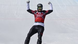 Eliot Grondin of Sainte-Marie Que. raises his arms as he wins the event and the Crystal Globe as the season’s overall winner, Sunday, March 24, 2024 at the FIS snowboard cross world cup event in Beaupre, Quebec. (THE CANADIAN PRESS/Jacques Boissinot)