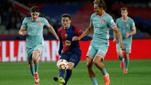 Barcelona's Gavi in action between Atletico Madrid's Julian Alvarez, left, and Marcos Llorente during a Spanish Copa del Rey, or King's Cup, the semi-final soccer match between Barcelona and Atletico Madrid in Barcelona, Spain, Tuesday, Feb. 25, 2025. (Joan Monfort/AP Photo)