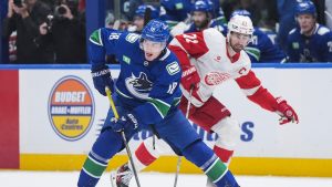 Vancouver Canucks' Drew O'Connor (18) skates with the puck under watch by Detroit Red Wings' Dylan Larkin (71) during second period NHL hockey action in Vancouver, B.C., Sunday, Feb. 2, 2025. (Darryl Dyck/THE CANADIAN PRESS)