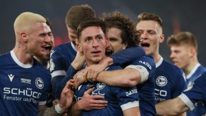 Bielefeld's goalscorer Marius Woerl, centre, celebrates scoring his side's first goal of the game during the German soccer cup quarter final soccer match between Arminia Bielefeld and Werder Bremen, at Schueco Arena in Bielefeld, Germany, Tuesday, Feb. 25, 2025. (Friso Gentsch/dpa via AP)