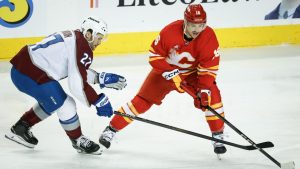 Colorado Avalanche's Jonathan Drouin, left, and Calgary Flames' Morgan Frost chase the puck during second period NHL hockey action in Calgary on Thursday, Feb. 6, 2025. (Jeff McIntosh/THE CANADIAN PRESS)