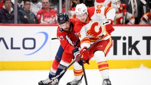 Washington Capitals right wing Tom Wilson (43) and Calgary Flames defenseman Brayden Pachal (94) battle for the puck during the first period of an NHL hockey game, Tuesday, Feb. 25, 2025, in Washington. (Nick Wass/AP)