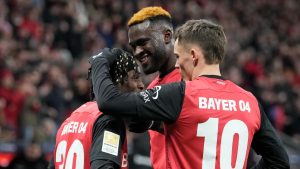 Leverkusen's Jeremie Frimpong, left, celebrates with teammates Victor Boniface and Florian Wirtz after he scored his side's second goal during the German Bundesliga soccer match between Bayer Leverkusen and TSG Hoffenheim at the BayArena in Leverkusen, Germany, Sunday, Feb. 2, 2025. (Martin Meissner/AP)