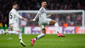 Real Madrid's Kylian Mbappe and Raul Asencio, left, run celebrating after a penalty shootout at the end of the Champions League round of 16, second leg, soccer match between Atletico Madrid and Real Madrid at the Metropolitano stadium in Madrid, Spain, Wednesday, March 12, 2025. (Manu Fernandez/AP)