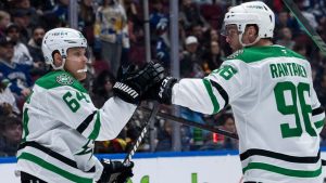 Dallas Stars' Mikael Granlund (64) and Mikko Rantanen (96) celebrate Granlund's goal against the Vancouver Canucks during second period NHL hockey action in Vancouver, B.C., Sunday, March 9, 2025. (Ethan Cairns/CP)