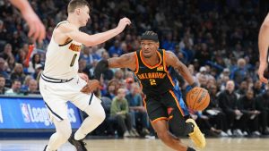 Oklahoma City Thunder guard Shai Gilgeous-Alexander (2) drives past Denver Nuggets guard Christian Braun (0) during the second half of an NBA basketball game, Sunday, March 9, 2025, in Oklahoma City. (AP Photo/Kyle Phillips)