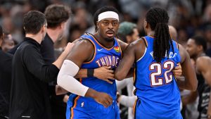 Oklahoma City Thunder guard Luguentz Dort, centre, and teammate Cason Wallace (22) walk to their bench after a scrum in the second half of their NBA basketball game against the San Antonio Spurs, Sunday, March 2, 2025, in San Antonio. (Darren Abate/AP Photo)