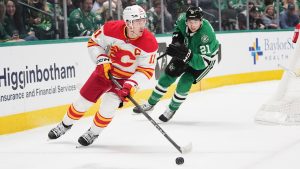 Calgary Flames centre Mikael Backlund (11) controls the puck in front of Dallas Stars' Jason Robertson (21) in the first period of an NHL hockey game in Dallas, Thursday, March 6, 2025. (Tony Gutierrez/AP)