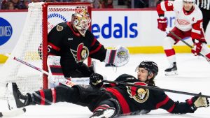 Ottawa Senators defenceman Jake Sanderson (85), bottom, blocks a shot as teammate Linus Ullmark (35) looks on during first period NHL hockey action against the Detroit Red Wings in Ottawa, on Monday, March 10, 2025. (Spencer Colby/CP)